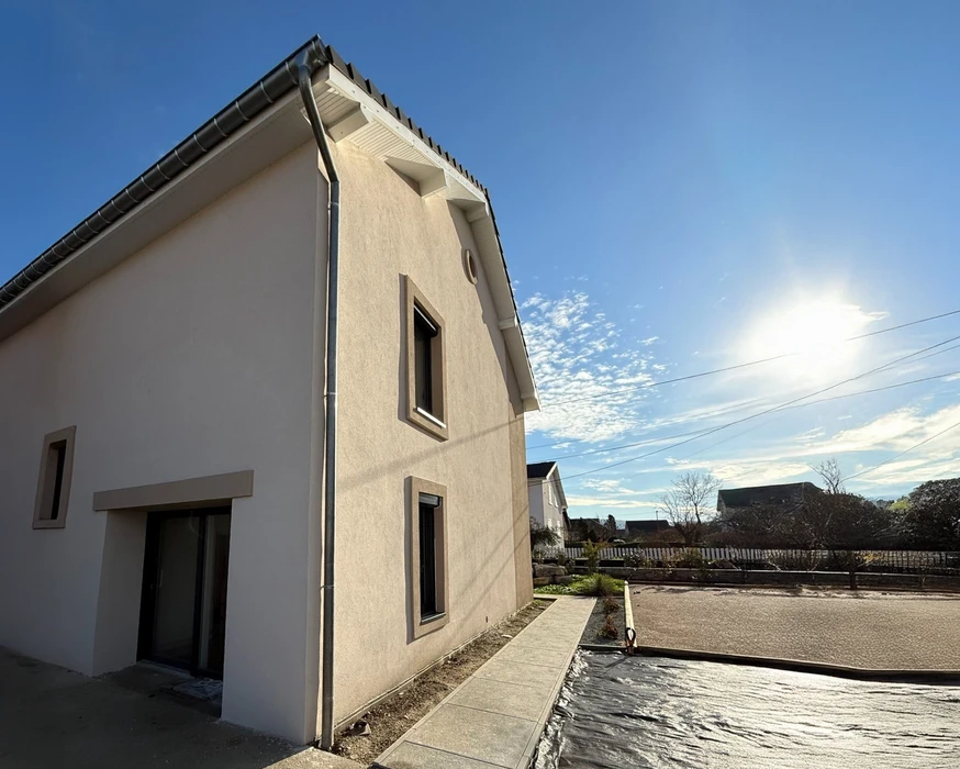 Chantier de rénovation intérieure avec cloison partiellement démontée révélant la structure en briques