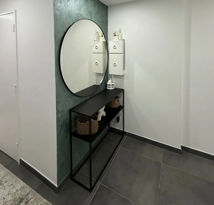 Chantier de construction résidentielle en cours, maison individuelle moderne avec façade blanche, toit en tuiles rouges et balcon à garde-corps métallique décoratif