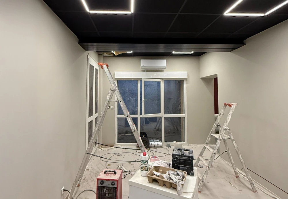 Façade d'une maison résidentielle moderne avec étage, murs enduits beige et gris, fenêtres à encadrements foncés, toiture tuiles terre cuite