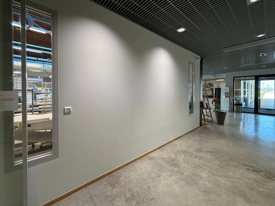 Façade d'une maison résidentielle moderne avec étage, murs enduits beige et gris, fenêtres à encadrements foncés, toiture tuiles terre cuite