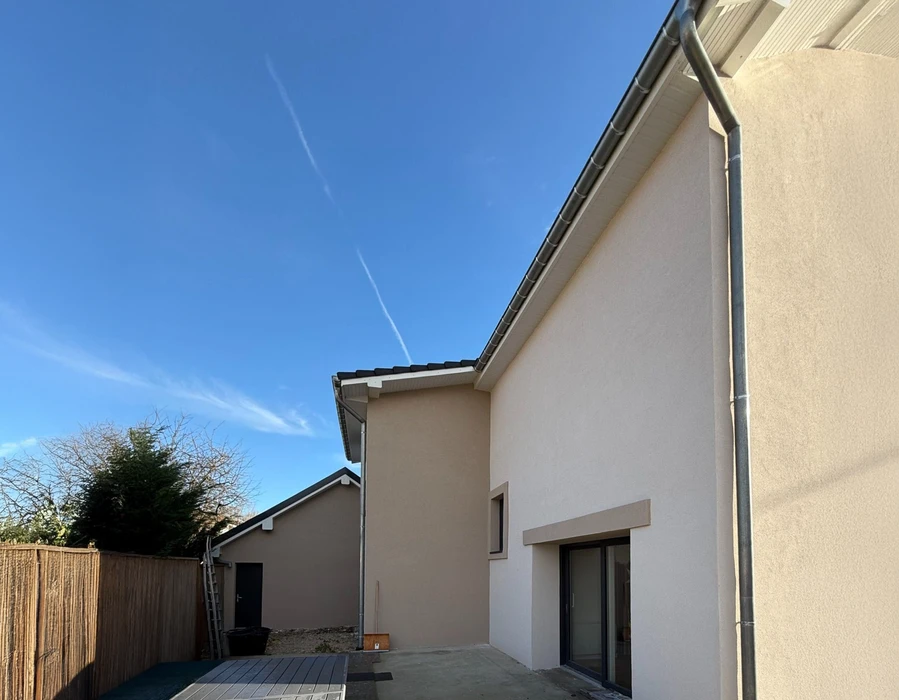 Façade de bâtiment commercial en cours de rénovation avec ouverture sans menuiserie et rideau métallique gris fermé