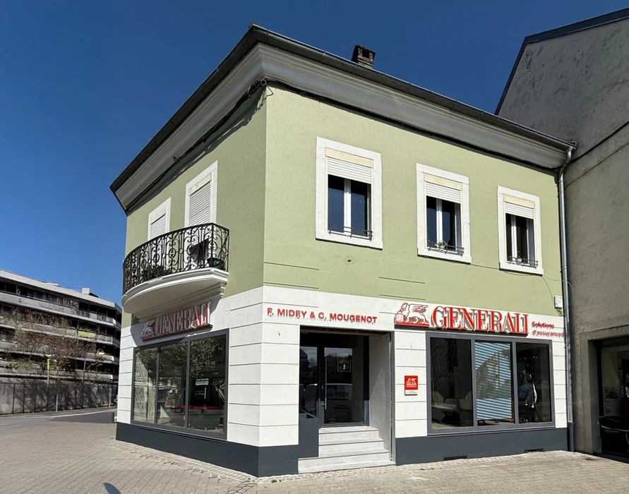 Façade d'immeuble résidentiel moderne avec porte d'entrée vitrée à carreaux et six fenêtres à volets roulants blancs disposées symétriquement sur deux étages