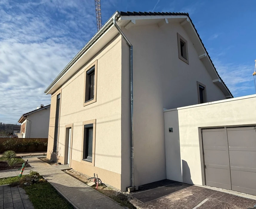 Façade d'immeuble résidentiel moderne avec porte d'entrée vitrée à carreaux et six fenêtres à volets roulants blancs disposées symétriquement sur deux étages